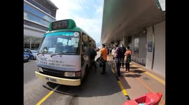 Visitors of Princess Margaret hospital wearing a mask climb into a minibus in the courtyard of the hospital