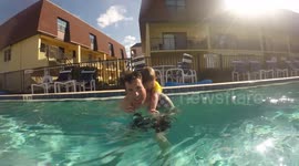 Toddler diving underwater with dad