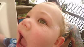 Toddler going down water slide with Dad