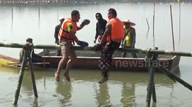 Muay Thai boxing enthusiasts fight on bamboo pole over a river