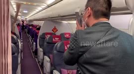 Passengers applaud after their Shanghai flight was rerouted to Wuhan sending residents back home during coronavirus outbreak
