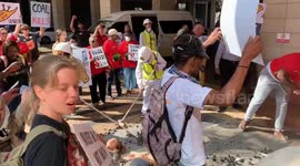 Environmental activists dump buckets of coal outside conference venue in Cape Town