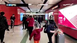 Commuters wear plastic bottles on heads at Chinese train station amid coronavirus outbreak