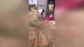 School teacher bound and beaten by political party representatives for protesting government land seizure in east India