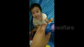 Mine! Baby in California tries corn dog for the first time and won't share