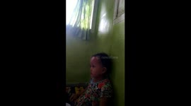 the moment of a 3-year-old girl in a sleepy field while eating