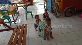 the activeness of a 2-year-old girl in the field arranging chairs, playing with water and wiping the floor