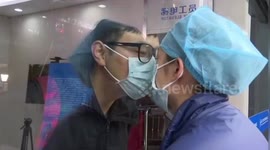 Chinese nurse working in coronavirus isolation ward kisses boyfriend through glass door