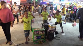 Thai school kids give a live performance in order to raise money for their education, at a temple fair.