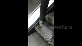 Man on the London Underground takes advantage of moving escalator to shine shoes