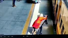 Moment son and piggybacking elderly mother almost fall under train in India