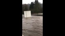 Resident of flood-hit UK town films massive container FLOAT past her front door