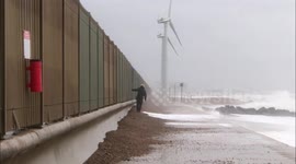 Man runs along pathway to avoid large waves during Storm Ciara