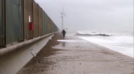 Man on beach pathway hit by large wave in Brighton during Storm Ciara