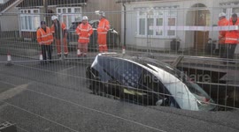 UK motorist has miracle escape after driving their car into a sinkhole that opened up on suburban street