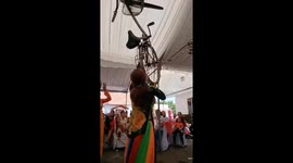 Vietnamese street performer dances while balancing bicycle on her mouth