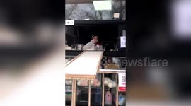 Beijing shop uses DIY slide to hand over food at safe distance amid coronavirus outbreak