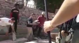 American tourists get down from Air Conditioned car to lend a helping hand to local labours working at a stone mine in western India