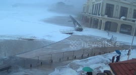Wave sends people running on seafront in Biarritz, France