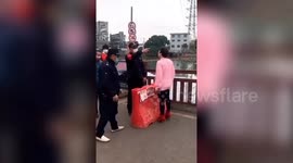 Chinese woman climbs over guardrails into river after being refused passage through coronavirus checkpoint