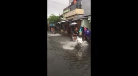 Using a scooter these Indonesians are waterskiing in the flood-hit town