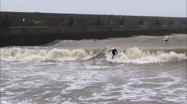 Surfers near Brighton on England's south coast catch some huge waves during Storm Dennis