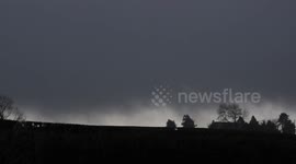 Storm Clouds & Blowing Snow Over Farm House