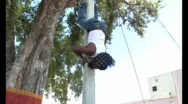 Man impressively climbs utility pole whilst upside down in southern India