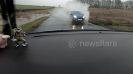 Car speeding on a flooded road