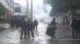 Riot police clash with masked protesters in Bogota