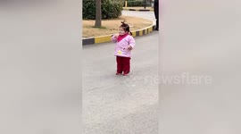 Hilarious moment toddler tries to eat biscuit through her face mask in China