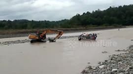 Bus full of passengers rescued using backhoe after getting stuck in flash flood in the Philippines