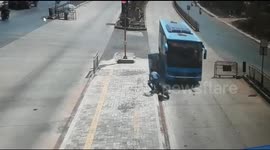 Bike rider making illegal U-turn narrowly avoids being crushed by bus in India