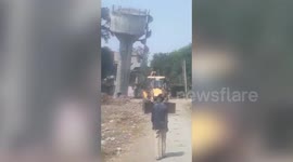 Bulldozer operator sent running when water tower collapses near his vehicle