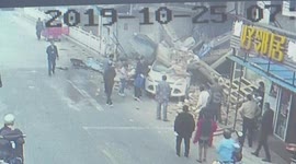 十字路口两车相撞 轿车失控撞塌楼房