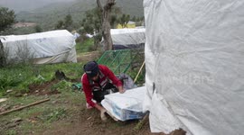 A Syrian refugee protect his tent under the heavy rain on the outside of the camp of Moria on the Greek island of Lesbos