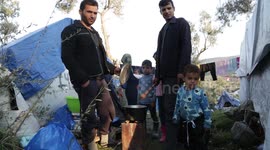 A refugee family cook with chicken broth outside the migrant and refugee registration camp in Moria.