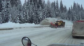 Snow plow passing big rigs parked on the trans-Canada HWY in British Columbia
