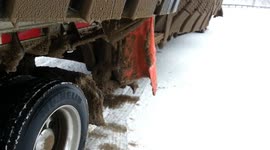Hauling oversize mining tyres in winter with a semi truck trailer in North America