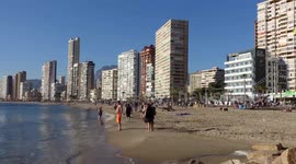 Timelapse of people on Levante beach, walking, standing and sunbathing