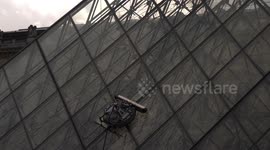 Cleaning Glass pyramid windows of museum Louvre in Paris.