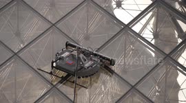 Robot cleaning pyramid glass windows of Louvre museum