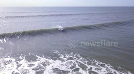 Aerial view as surfer braves cold Atlantic waves off New York coast