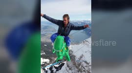 Highlining daredevil crosses Swiss mountain while wearing dinosaur costume