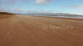 Dramatic drone footage captures gusts of wind blowing sand over UK beach