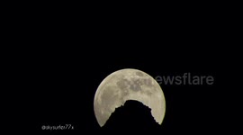 Moon rising behind the mountain peak in Switzerland