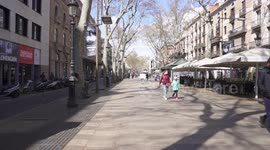 Two people with face masks are walking down the empty