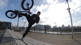 Man does BMX Bike Jump Trick on cool urban Location