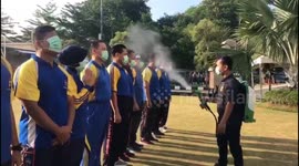 Police force in Indonesia sprayed with disinfectant to prevent COVID-19 spread
