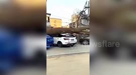 Strong winds blow over pedestrians and rip off building's external wall in Beijing